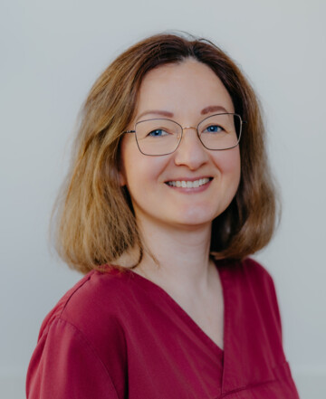 Portrait von Maria Libkina in rotem Kasak vor hellem Hintergrund